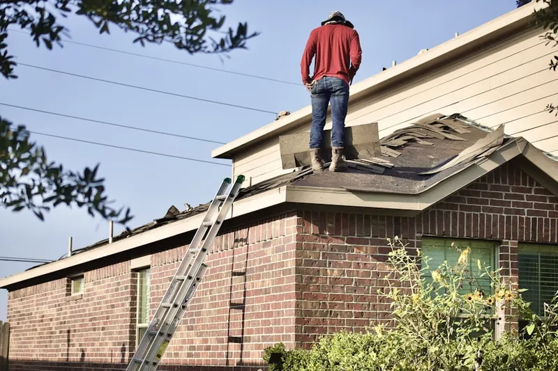 Professional roofer working on a residential roof in West Parish